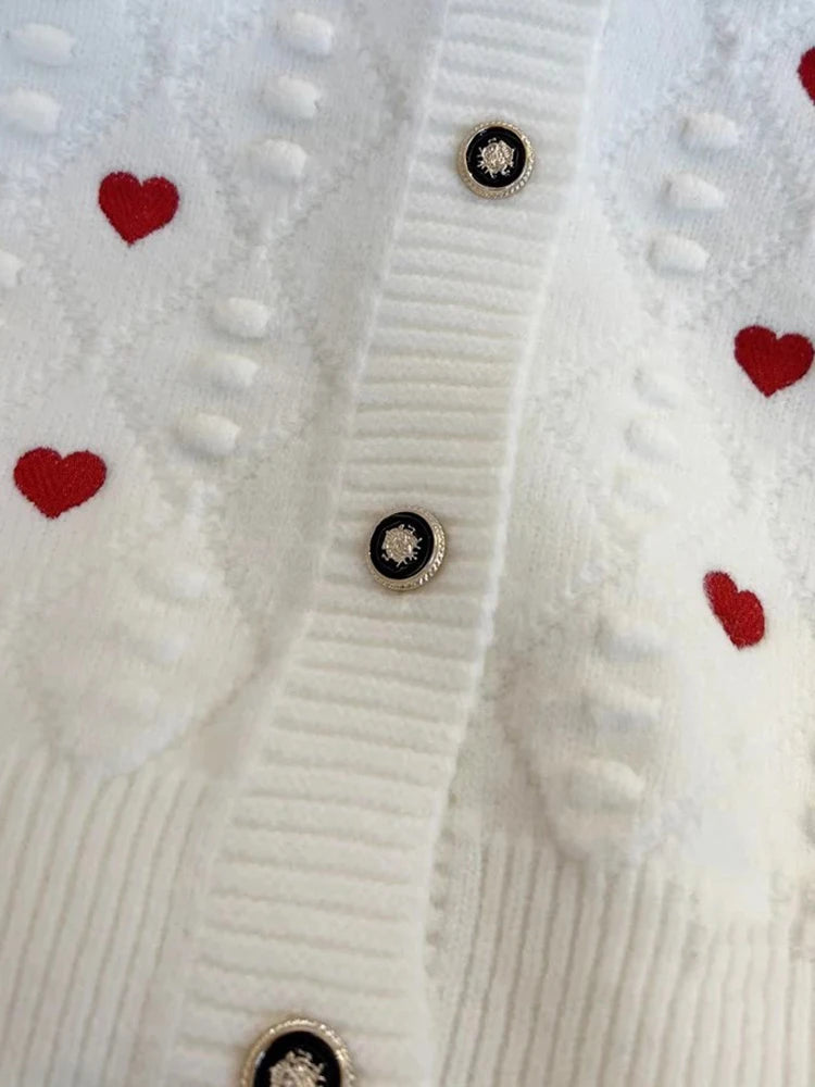 detail gilet blanc motif coeur rouge brodes a bouton 